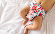 Load image into Gallery viewer, Lily Rumparooz One Size Cloth Pocket Diaper on a baby laying on a bed on size small
